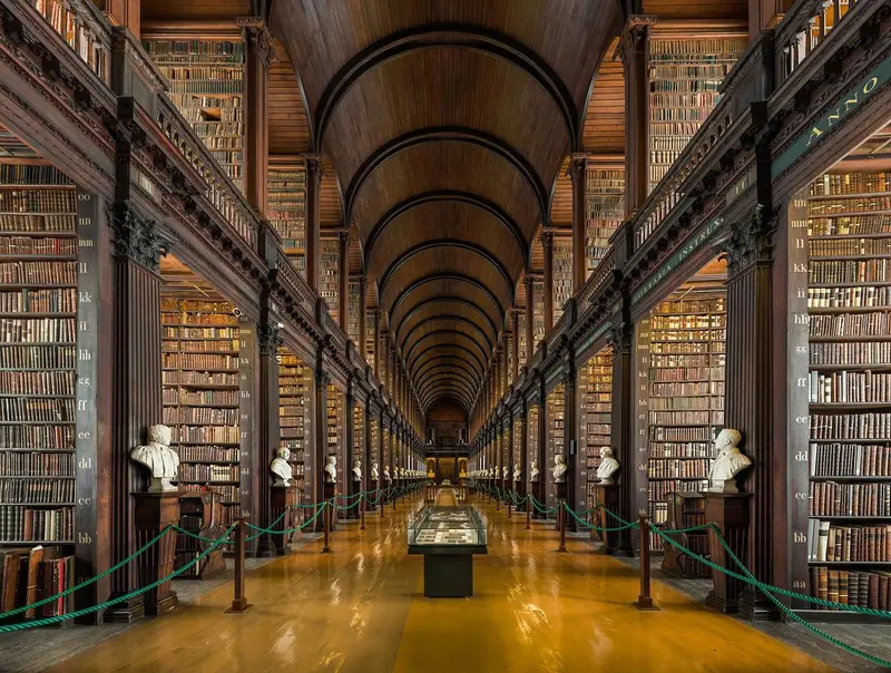 The Long Room of the Old Library at Trinity College Dublin, a barrel-vaulted hall lined with two storeys of bookshelves and marble busts.