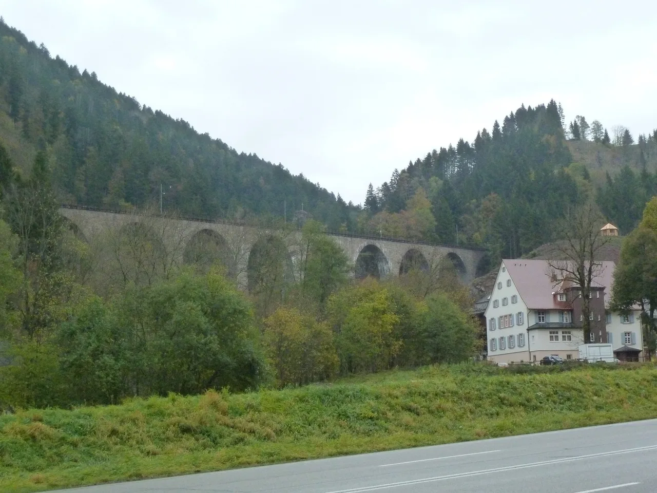 The nine-arch stone Ravenna railway viaduct crossing a wooded valley in the Black Forest, with a road in the foreground