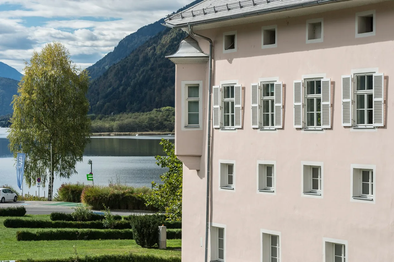 Corner oriel of the former Ossiach Abbey with a view over Lake Ossiach and the wooded mountains behind it