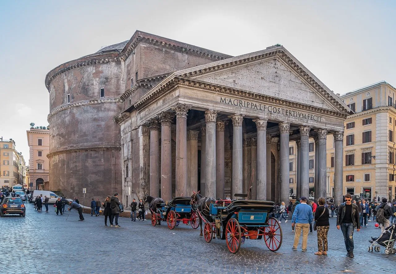 The columned portico and brick rotunda of the Pantheon on a cobbled square, with horse-drawn carriages and people in front.