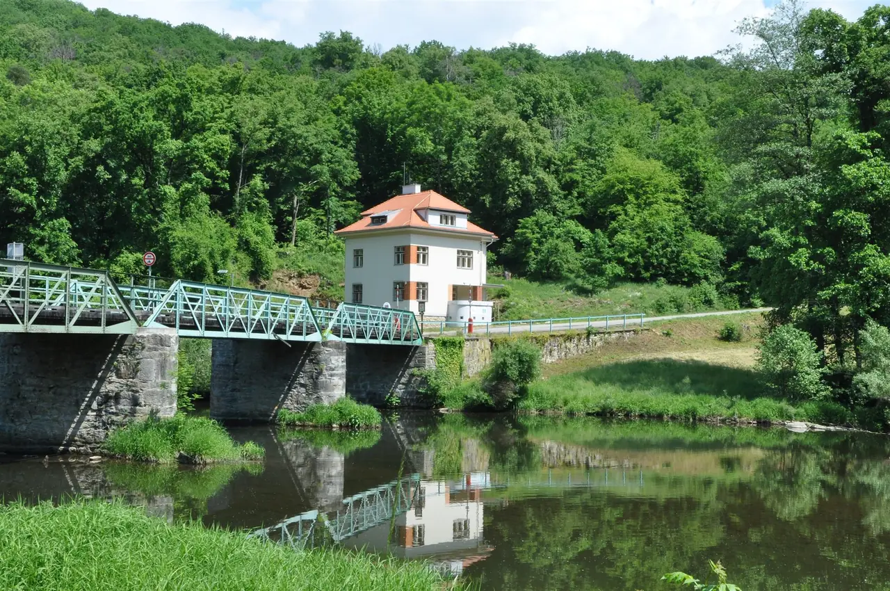 A steel bridge crosses the Thaya at Hardegg, with a white former customs house on the far bank and forested hills behind.