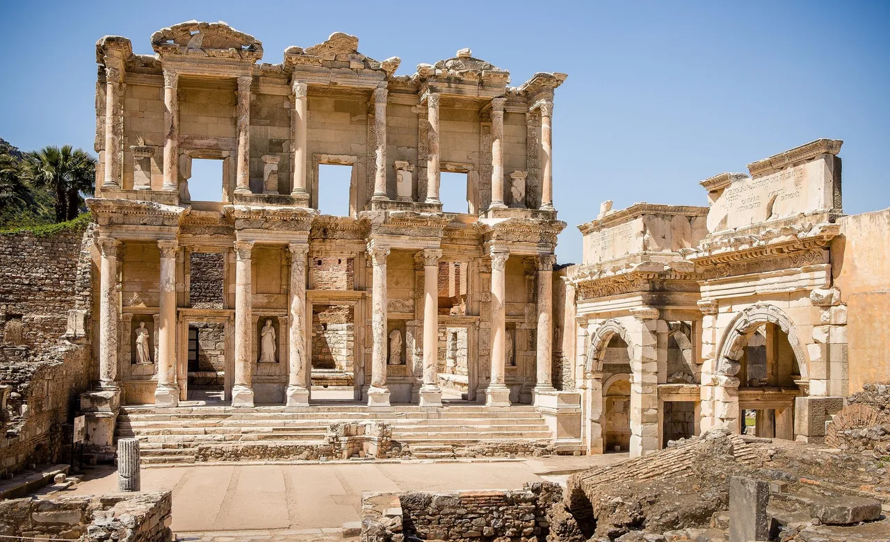 Facade of the Library of Celsus at Ephesus with its two storeys of columns, statues in niches and a neighbouring gate on the right